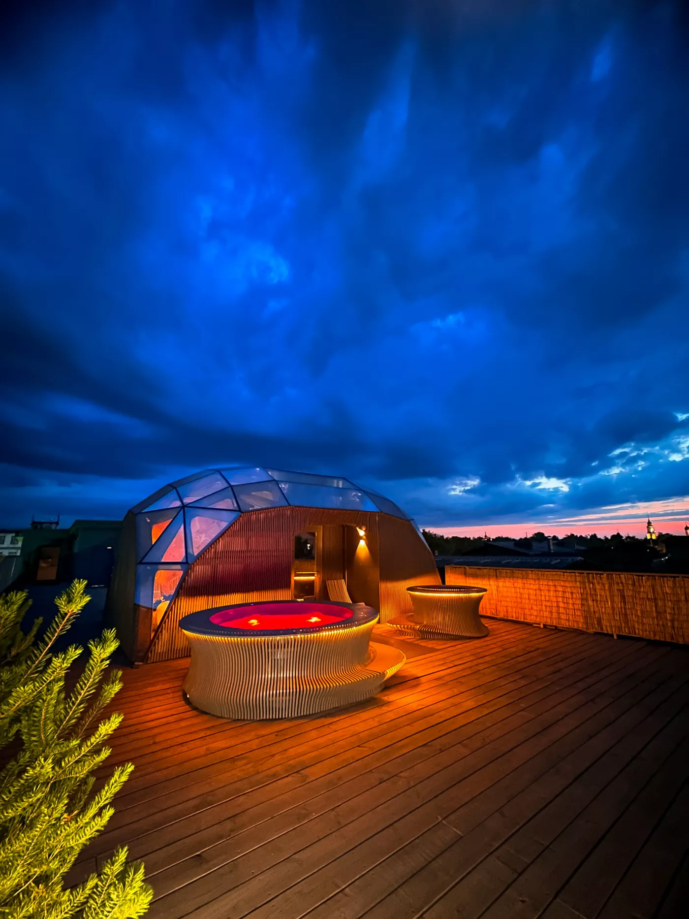 Модуль SkySpa с купелью на крыше в городе вечером